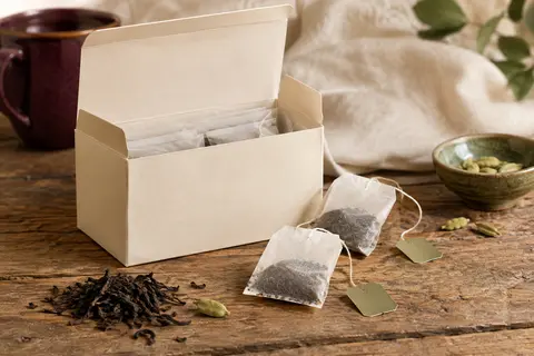 Tasse de thé noir à la cardamome avec sachet individuel et quelques capsules de cardamome verte